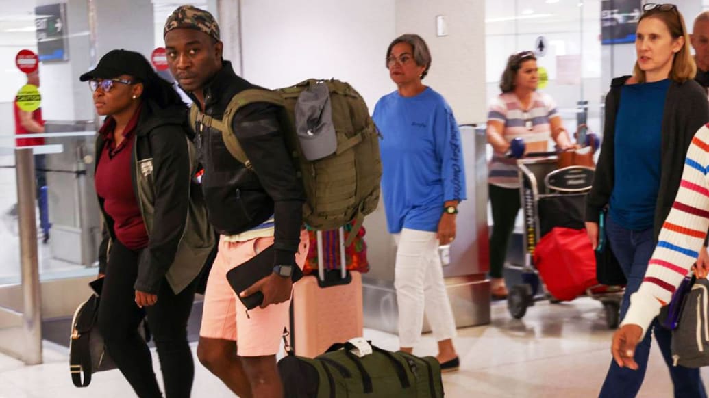 Passengers walk through the Arrivals area after arriving in Miami on the first evacuation flight out of Cap-Haitien, Haiti, earlier this month.