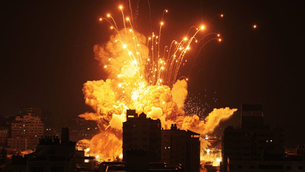 A photo including a missile exploding in Gaza City