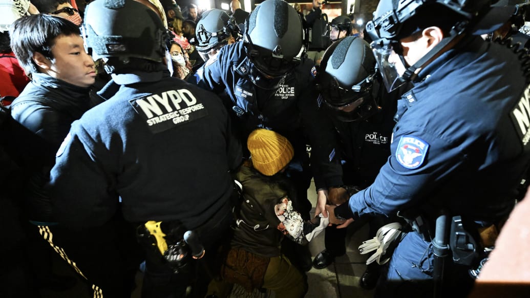 A photo including police arresting students at New York University