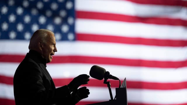 Image of Joe Biden speaking, with American flag in the background.