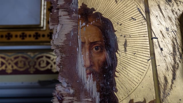  A damaged gilt Orthodox painting of Jesus Christ stands against a wall, as Ukrainians clear away debris after a Russian missile struck the historic Holy Transfiguration.