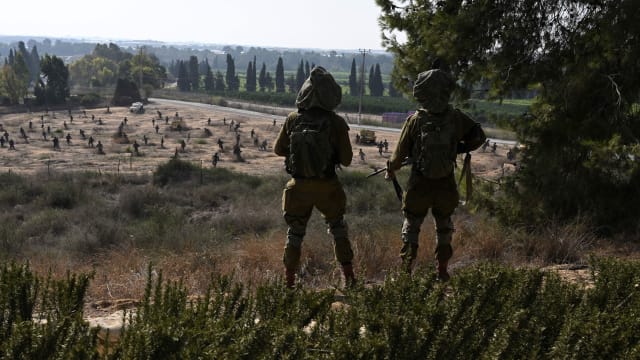 Two Israeli soldiers stand in Kibbutz Yad Mordechai, over looking a sculpture park in the grounds of the Yad Mordechai Museum, close to Israel's northern border with the Gaza Strip