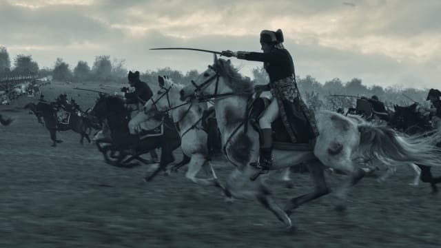 Joaquin Phoenix rides a horse in a still from "Napoleon"