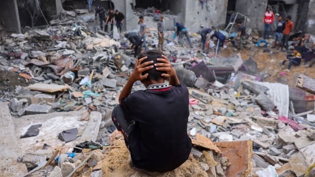 A child reacts as people salvage belongings amid the rubble of a damaged building following Israeli strikes on Rafah in southern Gaza, on Nov. 12, 2023.