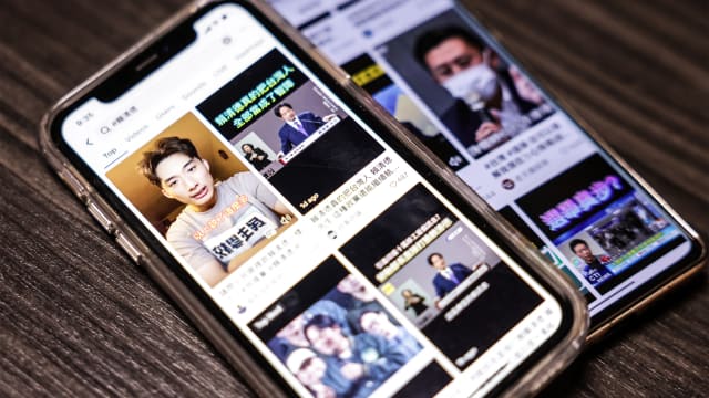 two mobile phones diplaying videos related to Taiwan's upcoming election on the TikTok app in Taipei.