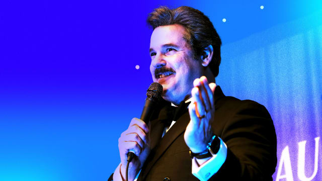Photo illustration of Paul F Tompkins on a blue and purple background