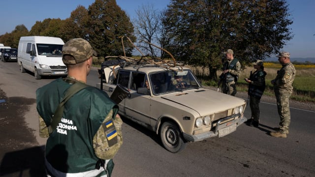 Ukrainian border guards and military recruitment officers check drivers’ papers at a checkpoint near the border to Romania as they look for men attempting to avoid military service.