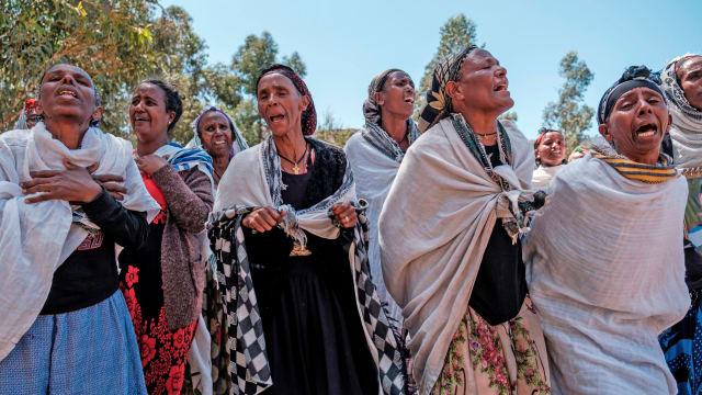 A group of mainly women cry and wail as they mourn the victims of a massacre in Dengolat, Tigray.