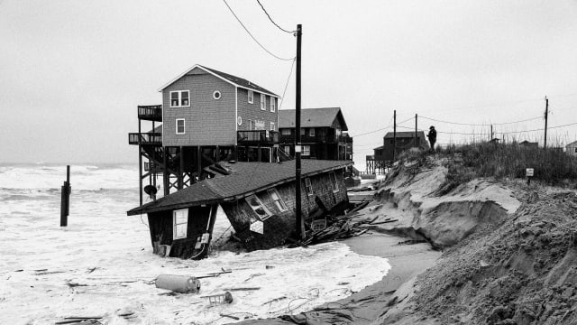 A one-story beach cottage falls into the Atlantic Ocean on the Outer Banks March 13, 2023.