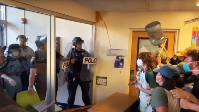 Protesters occupying Siemens Hall at Cal Poly Humboldt clash with police in riot gear who attempt to enter the building, on Monday Apirl 22, 2024. 