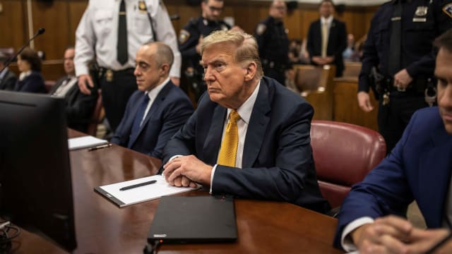 Donald Trump sits in a courtroom between his lawyers Emil Bove and Todd Blanche.