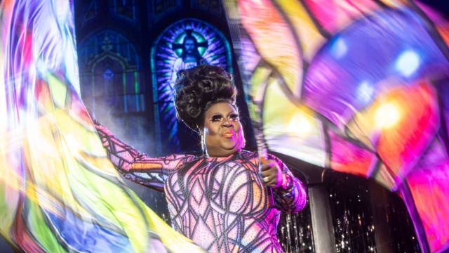 Latrice Royale waves flags in a church in a still from ‘We’re Here'