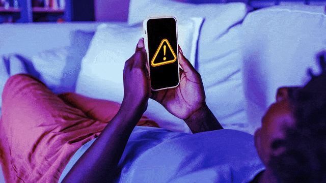 An animated gif of a person holding a phone with a warning sign.
