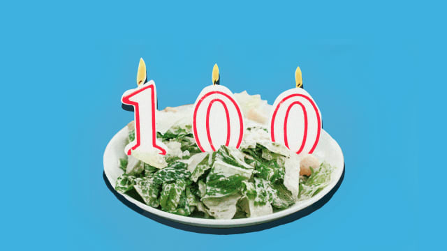 A Caesar salad with three 100th Birthday candles.