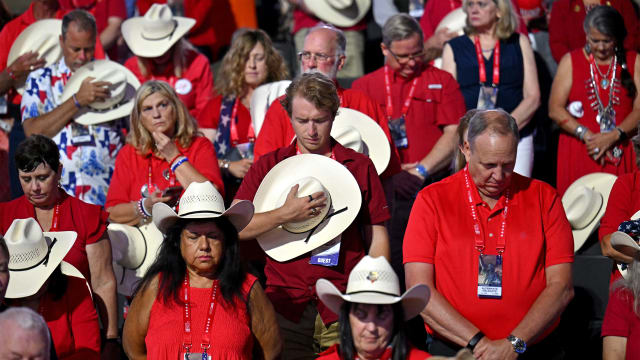 Delegates stand in prayer during the first day of the 2024 Republican National Convention.