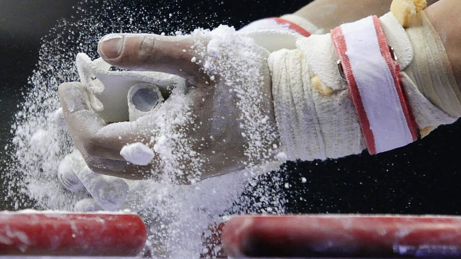 A gymnast rubs chalk before performing his routine during the qualification round of the Gymnastics World Championships in London October 13, 2009. 