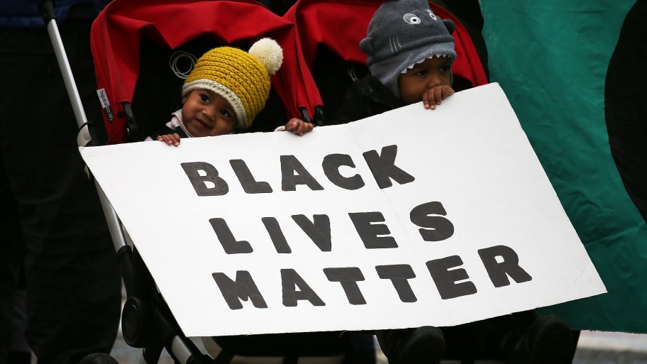 Malakai McCoy, 3yo (R) and his sister Amayah, 8-months holds a Black Lives Matter sign