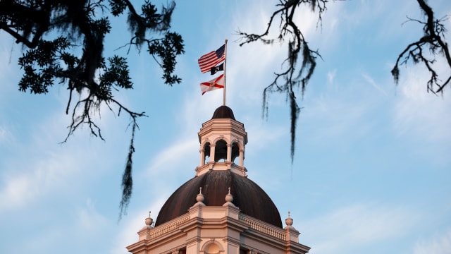 Flags fly atop the Florida Historic Capitol that is located near the 22-story New Capitol building