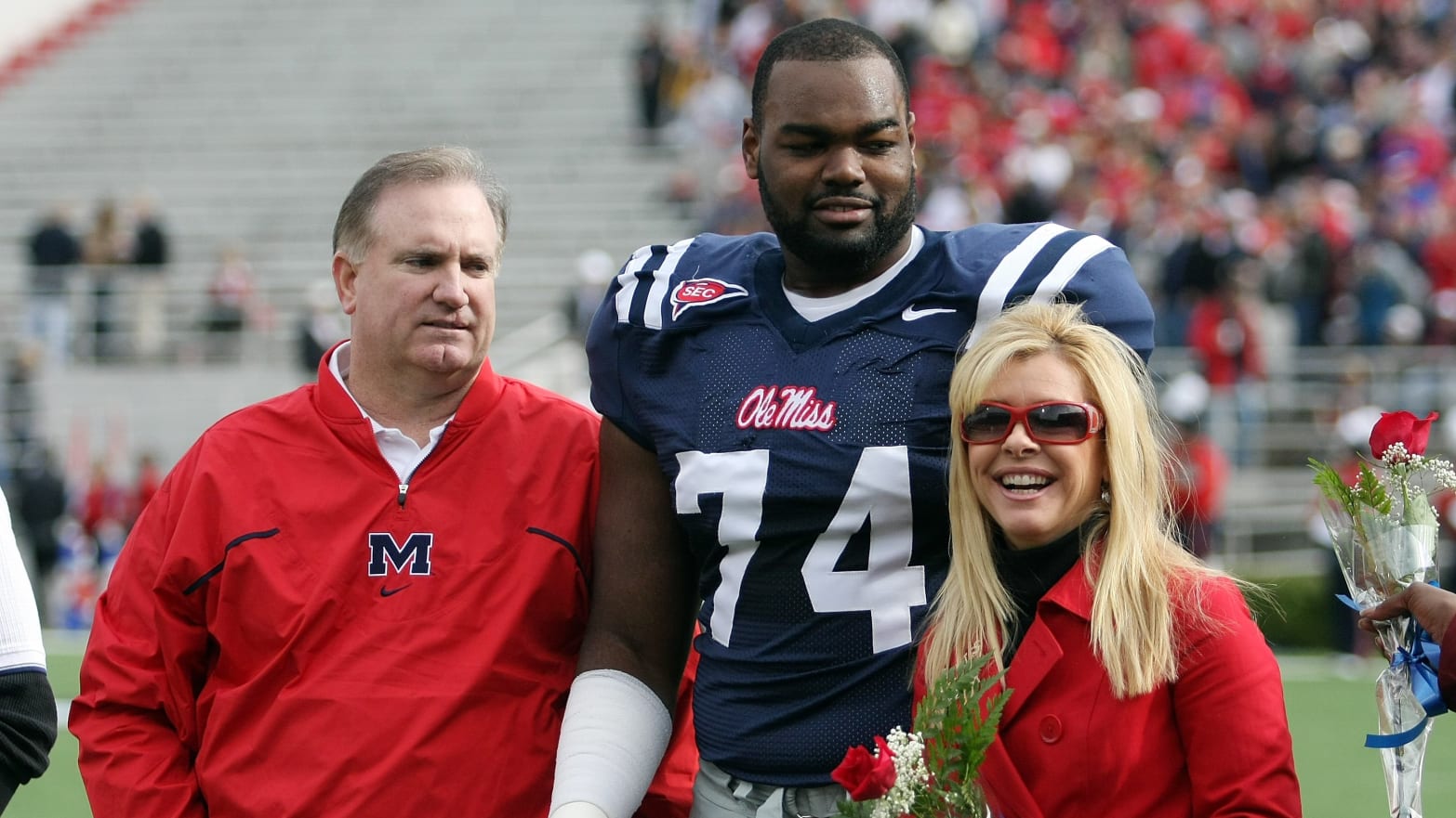 Sean Tuohy, Michael Oher, and Leigh Anne Tuohy during a football game in 2008. 