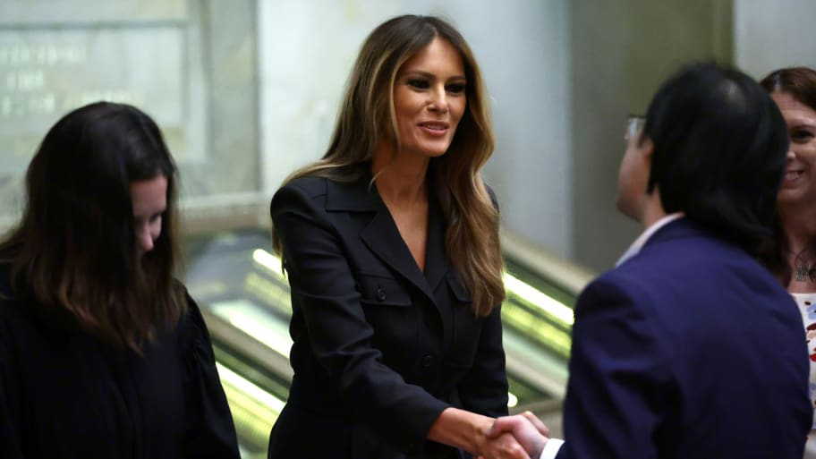 Former U.S. first lady Melania Trump (C) shakes hands with new U.S. citizens.