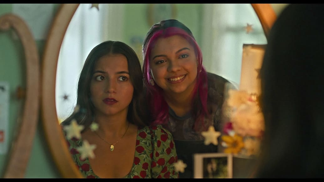 Cree and Isabella Merced look in a mirror in a still from ‘Turtles All the Way Down’