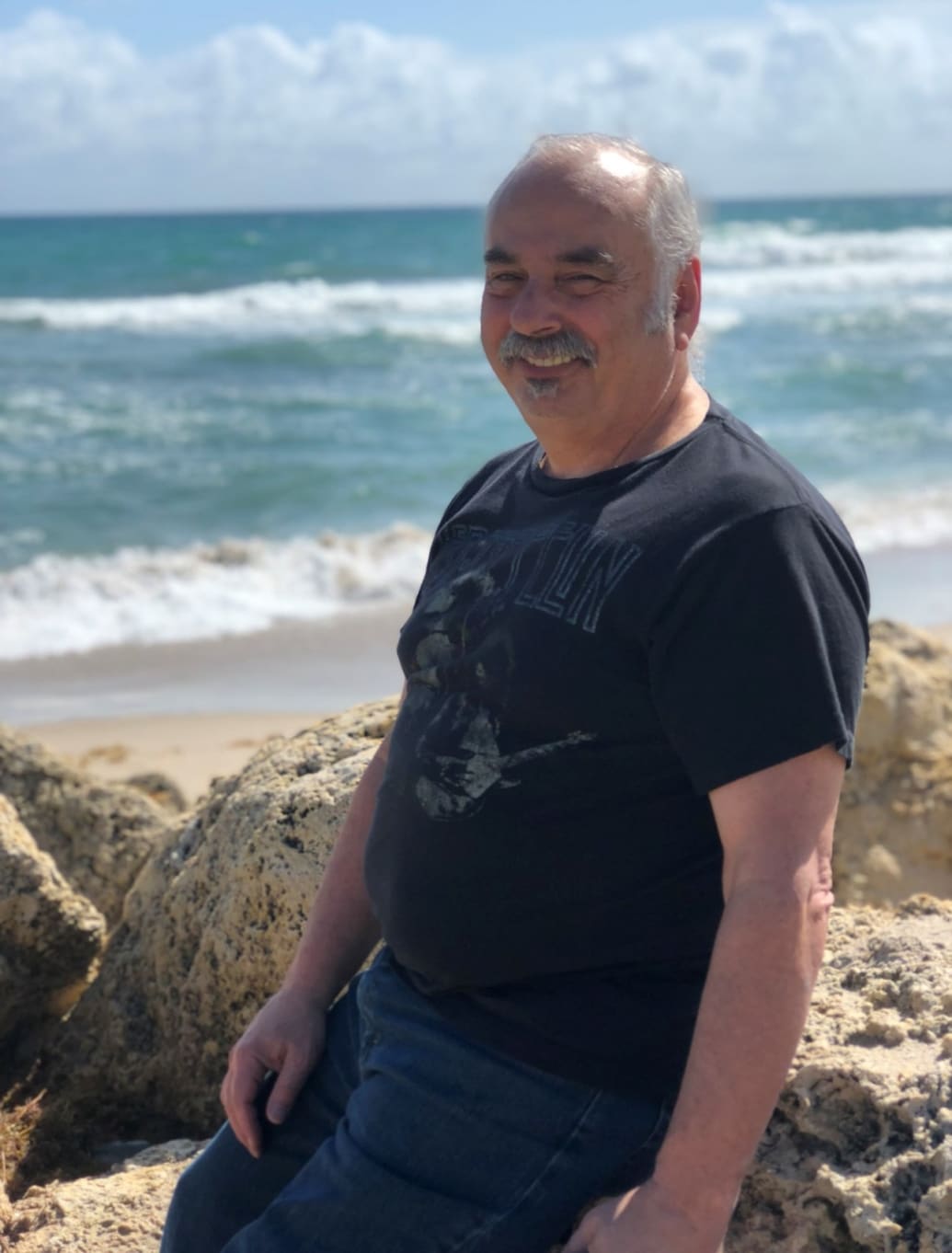 Clifford Zaner on the beach, in a Led Zeppelin T-shirt.