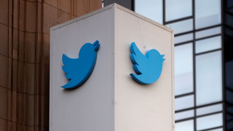 Twitter logos are displayed outside a company headquarters building.