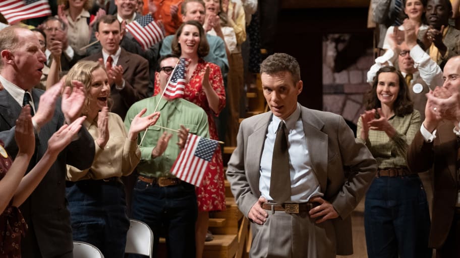 Cillian Murphy’s J. Robert Oppenheimer walks through a crowd of patriots waving American flags with 50 stars on them.