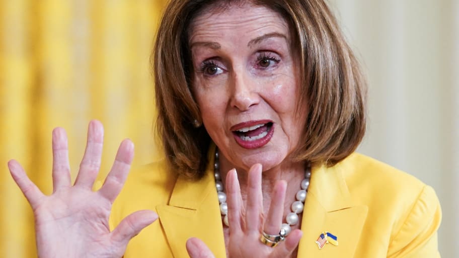 Nancy Pelosi speaks during an event with her hands raised.