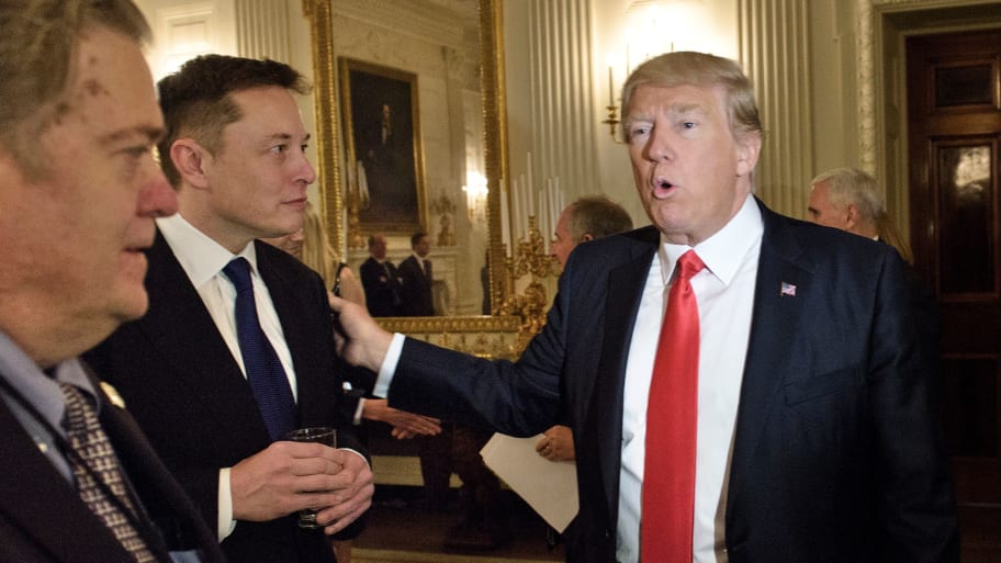 Trump advisor Steve Bannon watches as US President Donald Trump greets Elon Musk.