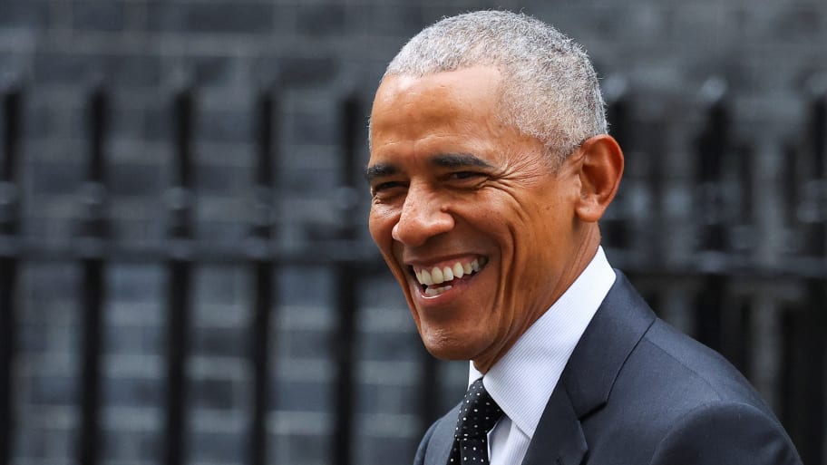 Barack Obama smiles in a suit as he visits London.