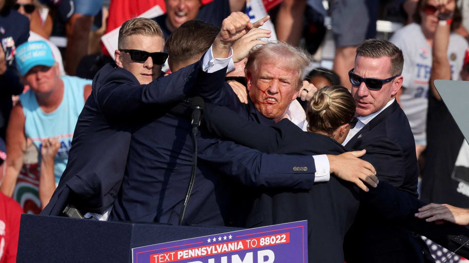 Donald Trump gestures to the crowd after being hit by a bullet at a campaign rally.