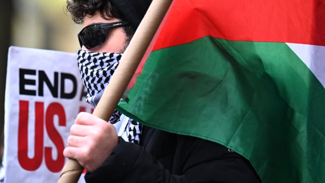 A pro-Palestinian protester carries a Palestinian flag outside the Columbia University campus in New York City, on April 24, 2024.