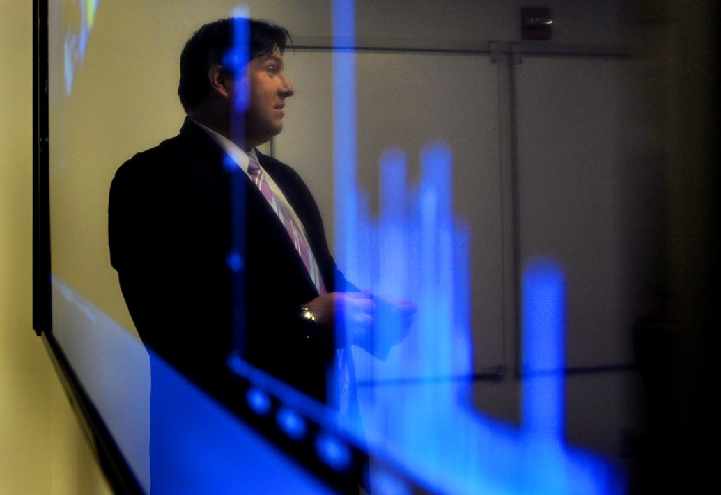 Jim Penrose is reflected in a monitor that he used as he gave a demonstration of the Darktrace software