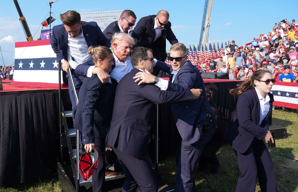 Donald Trump is assisted offstage by the Secret Service