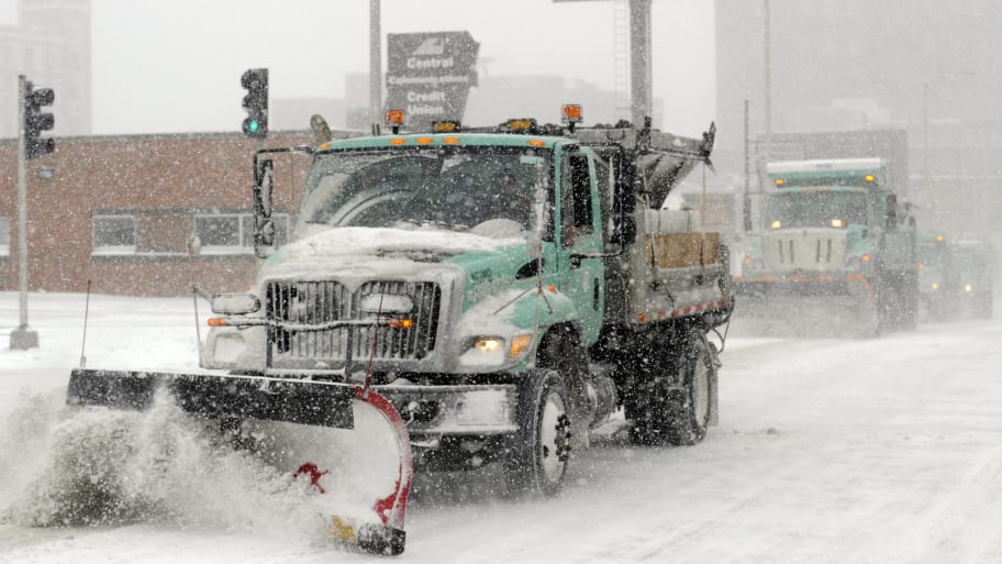 Snowplows clear a downtown street during a blizzard in Kansas City. 