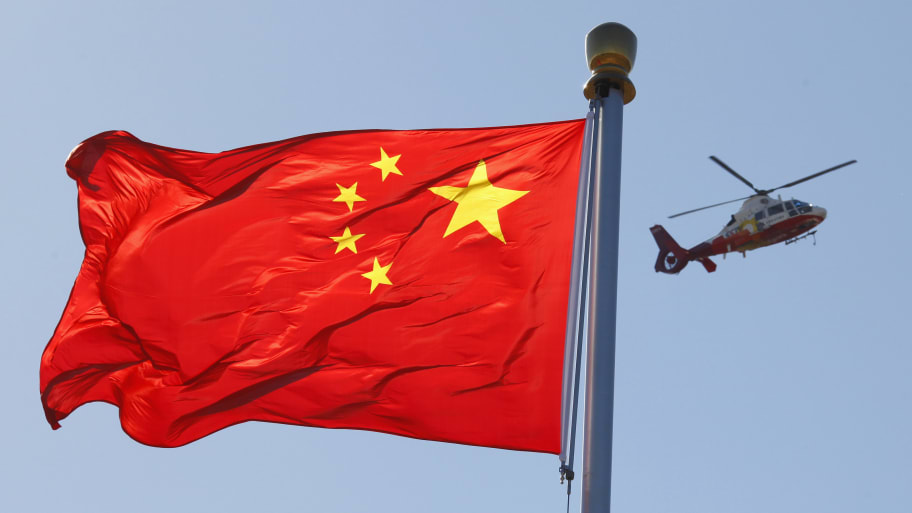 A China Central Television (CCTV) helicopter flies over the Chinese national flag in Tiananmen Square October 9, 2012.     