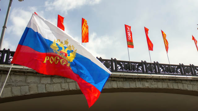 Russian flag is seen next to banners saying "Victory" on Victory Day. 