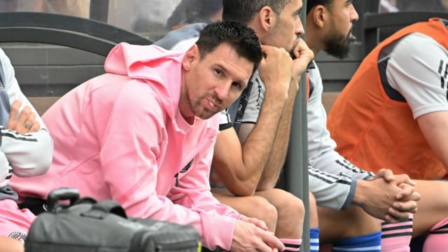 Inter Miami's Argentine forward Lionel Messi (L) sits on the bench during the friendly football match between Hong Kong XI and US Inter Miami CF