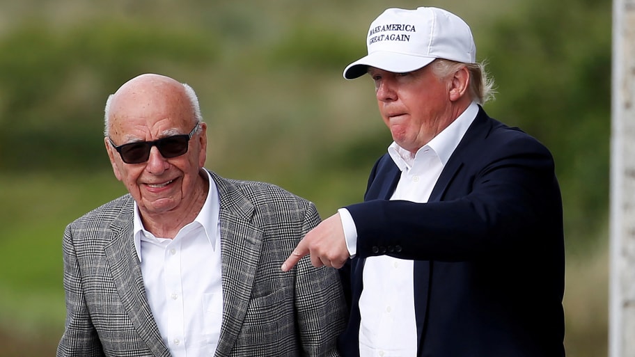 Republican presidential candidate Donald Trump (R) speaks to media mogul Rupert Murdoch as they walk out of Trump International Golf Links