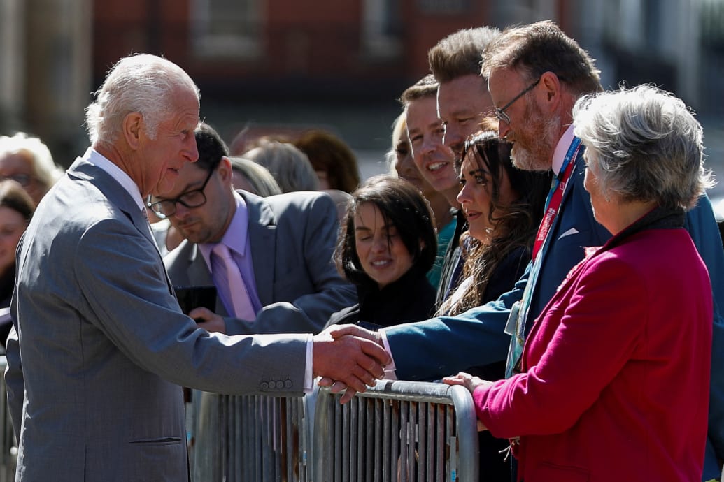 King Charles shakes hands with a man, as he meets with people affected by and family members of the victims of a mass stabbing attack, during a community visit, in Southport, Britain, August 20, 2024.