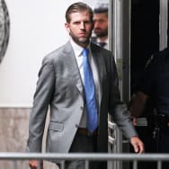 Eric Trump, wearing a suit, exits a New York City courthouse.