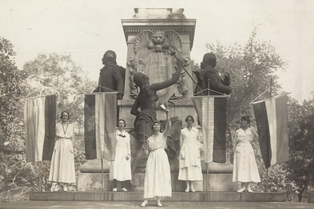 A photograph of Suffrage protestors burning a speech by President Wilson at Lafayette Statue in Washington, D.C. in 1918.