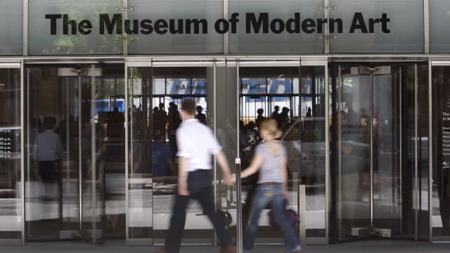Entrance to the Museum of Modern Art with people walking in front.