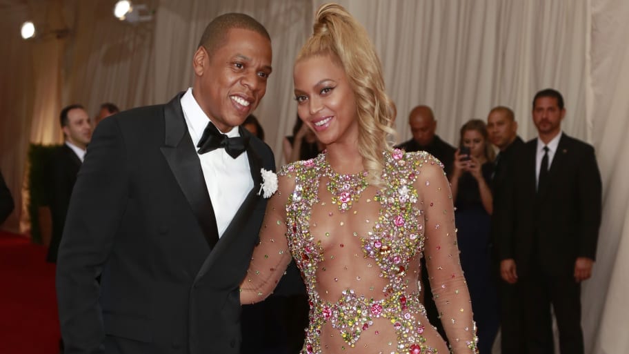 Beyonce smiles next to her husband, U.S. rapper Jay Z, after arriving for the Metropolitan Museum of Art Costume Institute Gala 2015