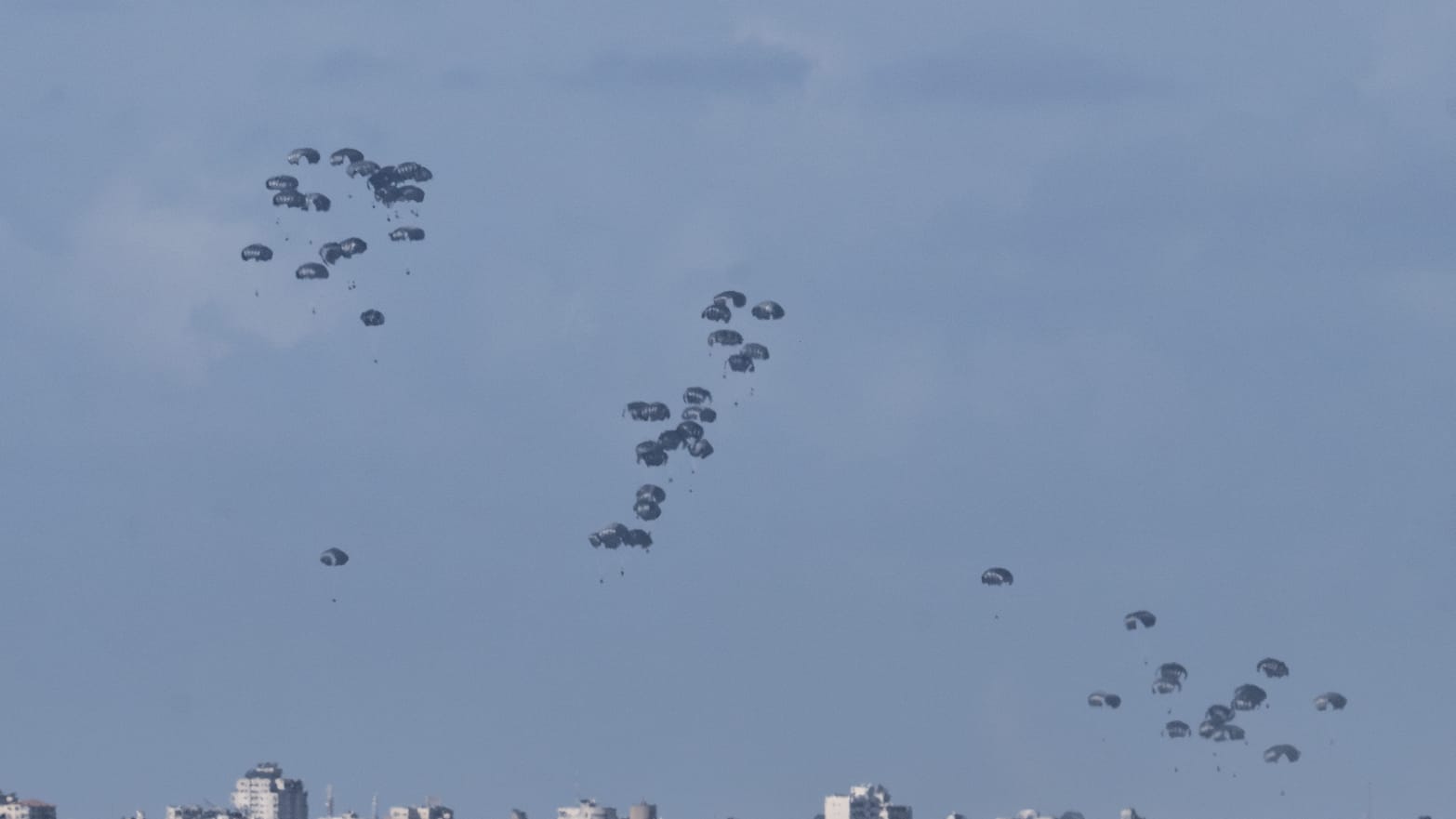 Military cargo plane drops humanitarian aid packages with parachutes over Gaza on March 07, 2024.