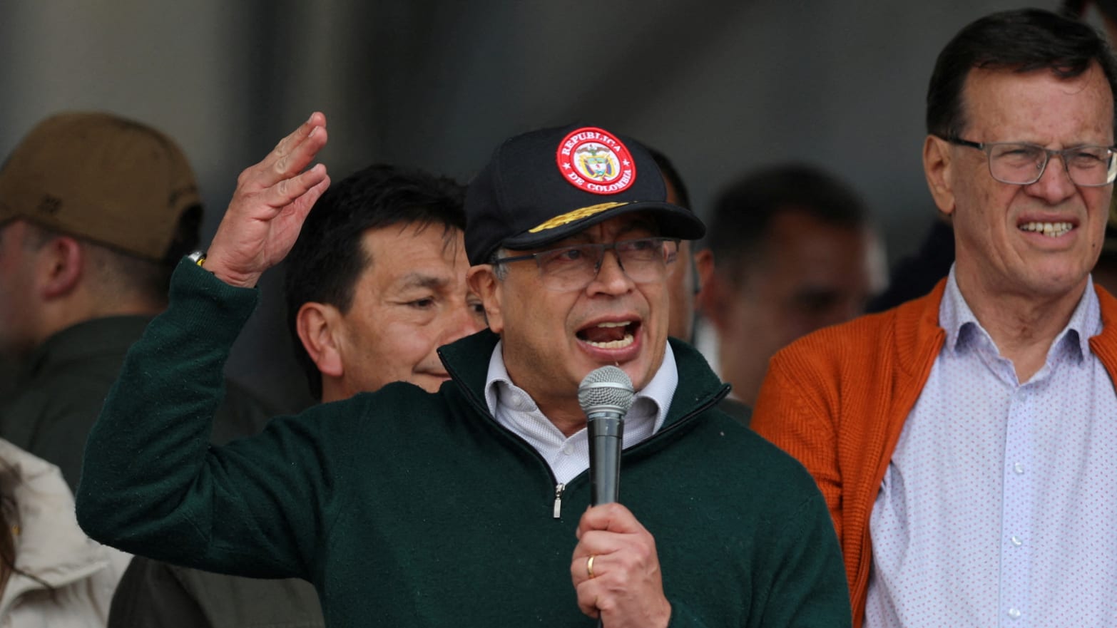 Colombia's president wearing a cap, holding a microphone, gesticulating