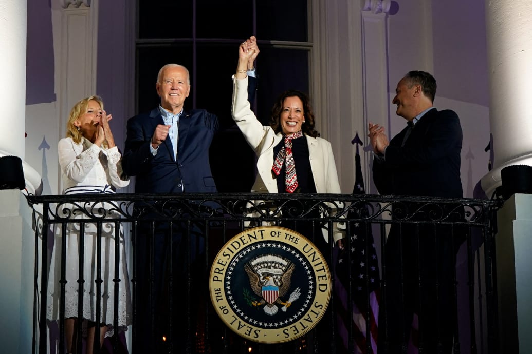 U.S. President Joe Biden and Vice President Kamala Harris raise their hands as they stand on a White House balcony with first lady Jill Biden and second gentleman Doug Emhoff during an Independence Day celebration in Washington, U.S., July 4, 2024.