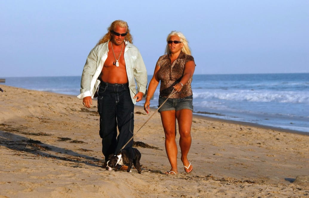 Duane 'Dog' Chapman and Beth Smith walk on the beach