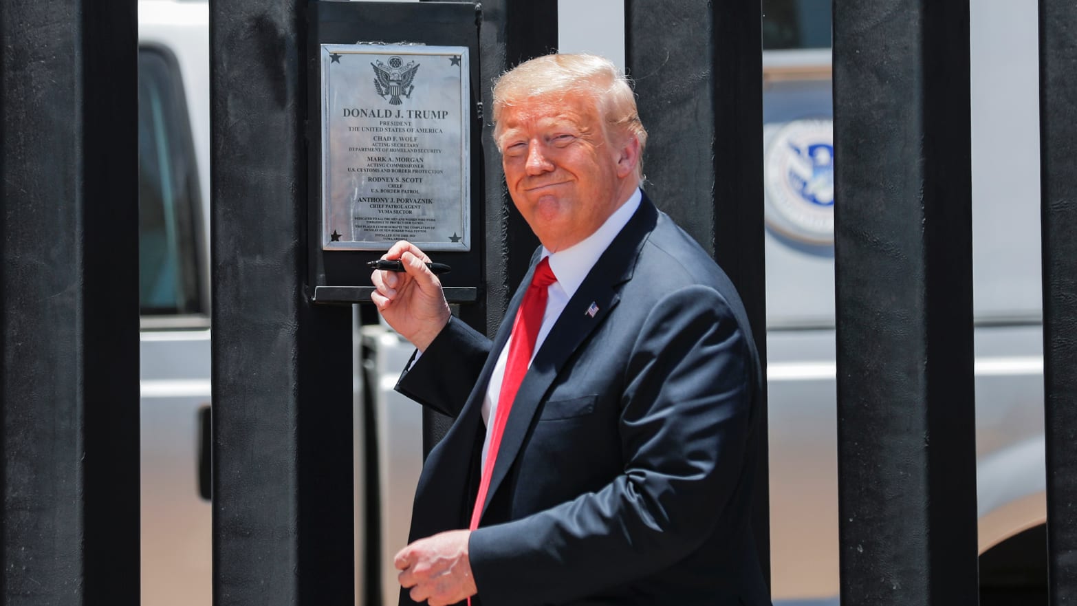 President Donald Trump smiles as he prepares to autograph a plaque commemorating the construction of the 200th mile of border wall while visiting the wall on the U.S.-Mexico border in San Luis, Arizona, U.S., June 23, 2020